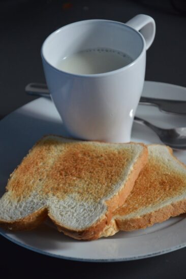 white ceramic mug beside toasted bread
